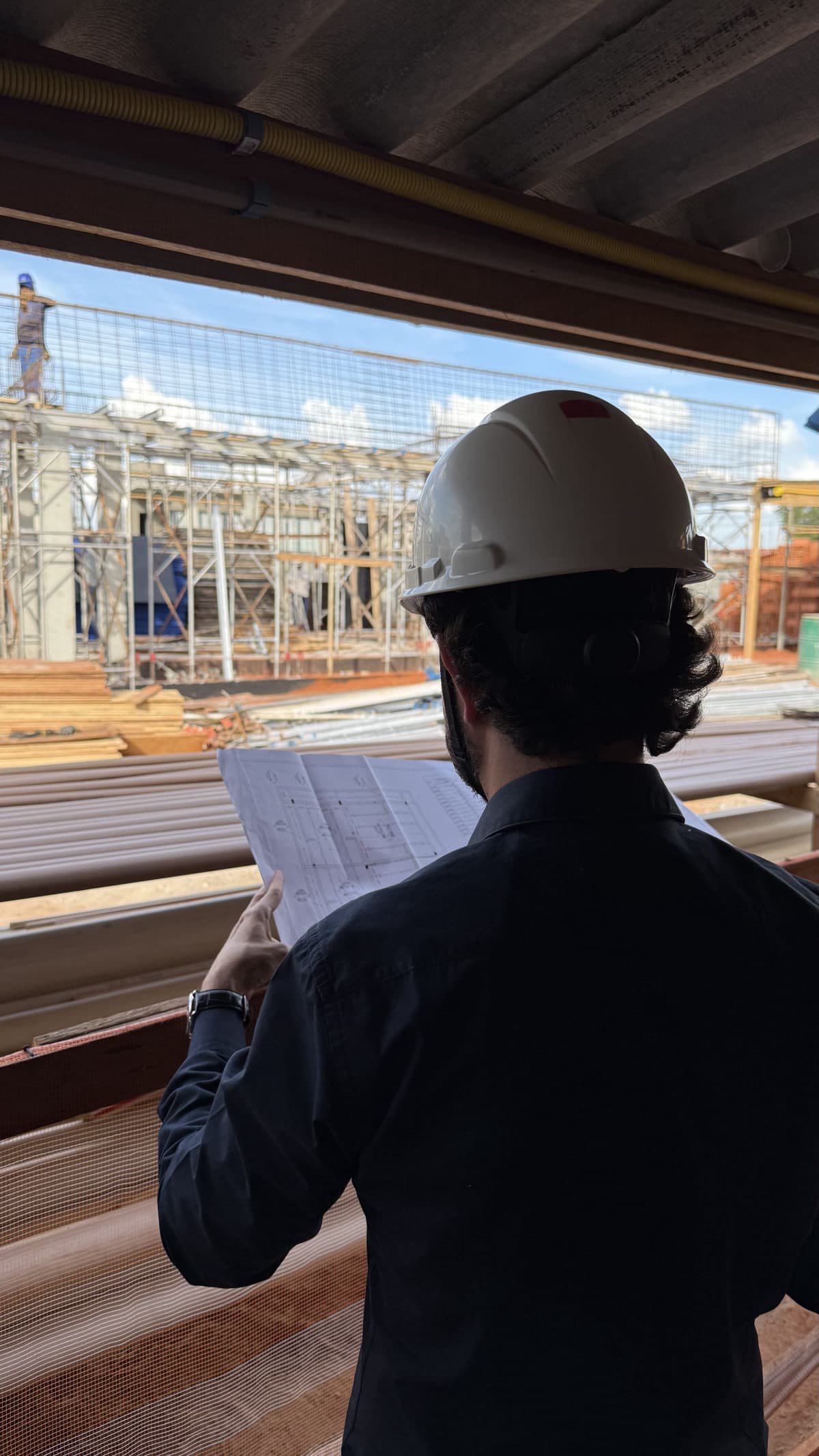 Engenheiro conferindo a planta no canteiro de obras
